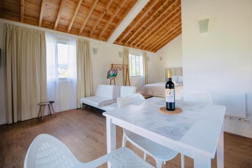 a living room with a white table with a bottle of wine on it at Azores Casa Hawaii in Nordeste
