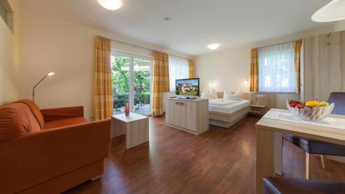 a living room with a couch and a television at Sonnenhof Hagnau in Hagnau