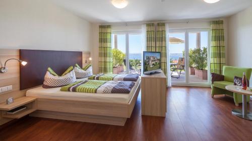 a bedroom with a large bed and a balcony at Sonnenhof Hagnau in Hagnau