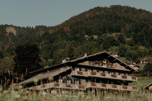a large building with balconies on the side of a mountain at Hôtel Les Roches Fleuries in Cordon