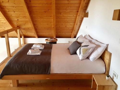 a large bed in a room with wooden ceilings at Planinska Koliba Exclusive in Sekulić 