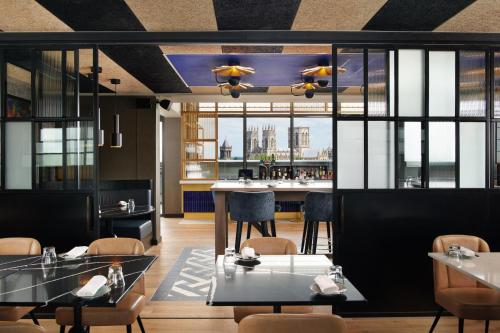 a restaurant with tables and chairs and a bar at Malmaison York in York