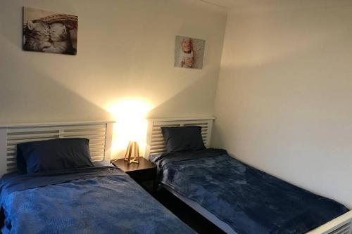 a bedroom with two beds and a lamp on a table at Liverpool holiday apartment 2Bedroom 2Bathroom in Liverpool