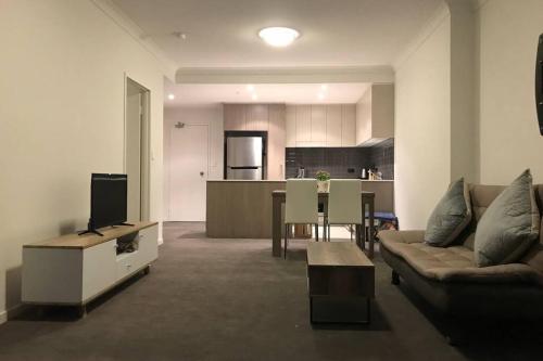 a living room with a couch and a tv and a kitchen at Liverpool holiday apartment 2Bedroom 2Bathroom in Liverpool
