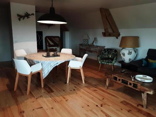 een woonkamer met een tafel en stoelen en een bank bij chambre k au domaine du mont scolan in Montgardon