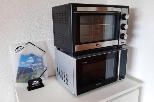 a microwave sitting on top of a box on a table at Le Tracouet - Central et cosy studio in Nendaz