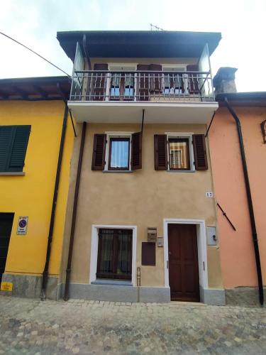Casa amarilla con balcón y puerta en La Casa di Vitto en Boves