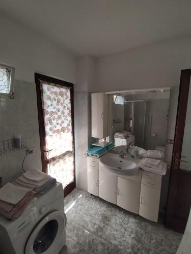 a bathroom with a washing machine and a sink at La Casa di Vitto in Boves