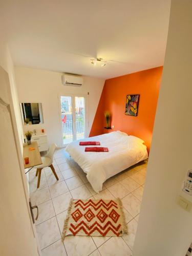 a bedroom with an orange wall and a bed at spacieux T5, terrasse, proche centre,parking privé in Perpignan
