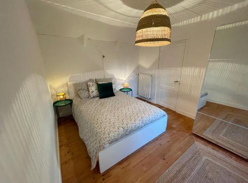 a bedroom with a white bed and two tables with lamps at Little Omaha in Vierville-sur-Mer