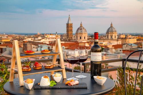 a bottle of wine and a glass on a table with food at Sophie Terrace Hotel in Rome