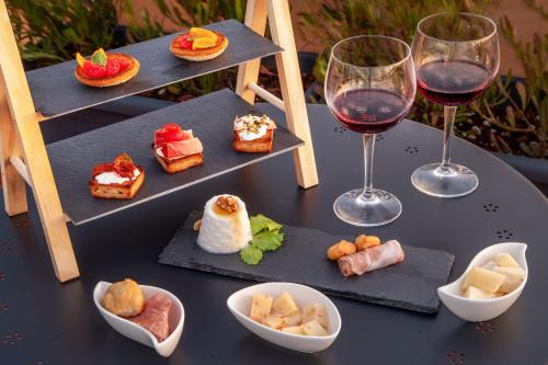 a table with three plates of food and two glasses of wine at Sophie Terrace Hotel in Rome