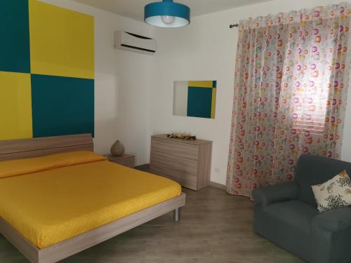 una camera con letto giallo e sedia di RosyMario a Castellammare del Golfo