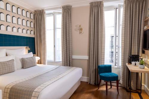 a hotel room with a bed and a desk at Hotel Sleeping Belle in Paris