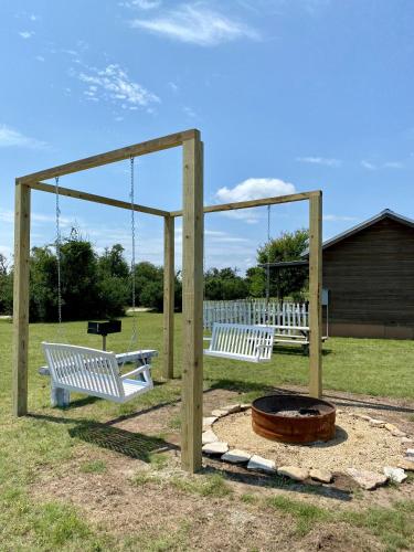 two swings and a fire pit in a park at City on a Hill at Spring Creek in Fredericksburg