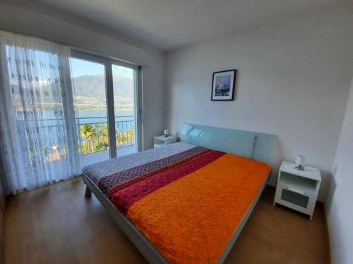 a bedroom with a bed and a large window at Casa Montana in San Nazzaro