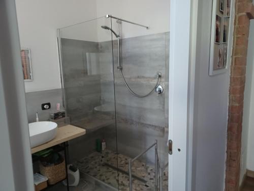a bathroom with a glass shower with a sink at L'Albero Di Gamelì in Chiusi