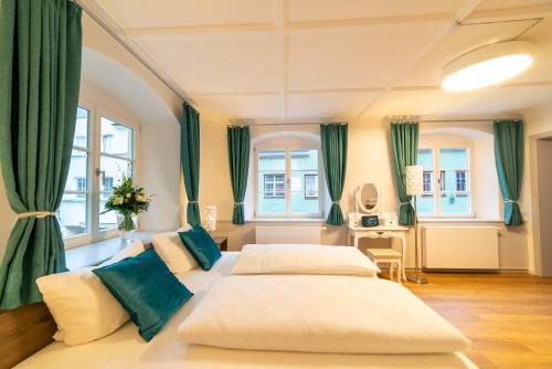 メミンゲンにあるUrban Flair Hotelのベッドルーム(ベッド2台、緑のカーテン付)