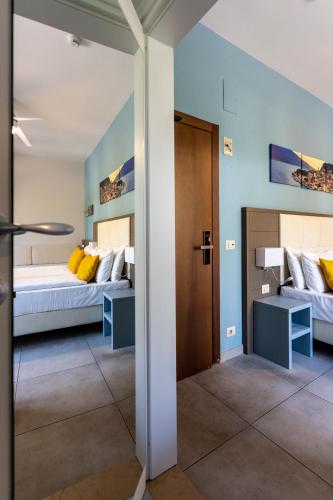 a bedroom with two beds with yellow pillows at Hotel Limone in Limone sul Garda