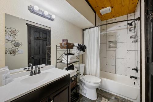 ein Badezimmer mit Waschbecken, Toilette und Dusche in der Unterkunft Smoky Mountain Chalet in Pigeon Forge