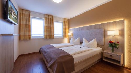 a bedroom with a large bed in a room with windows at Sonnenhof Hagnau in Hagnau