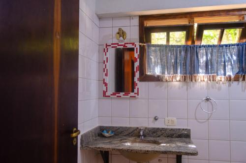 a bathroom with a sink and a mirror at Casa Ilhabela - melhor custo benefício in Ilhabela