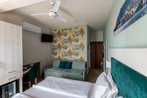 a bedroom with a couch and a painting on the wall at Hotel Limone in Limone sul Garda