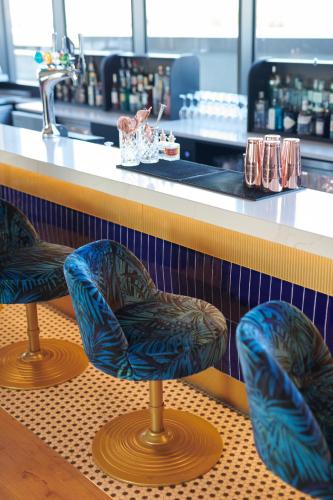 three blue chairs sitting in front of a counter at Malmaison York in York
