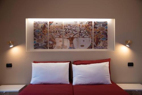 a bed with two pillows and a painting above it at Agriturismo Cascina Costa in Cassago Brianza