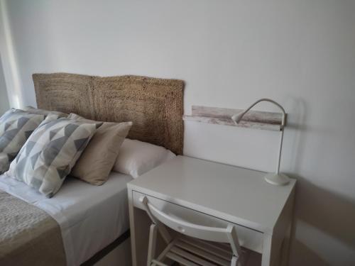 a bed with a white table and a chair next to it at VFT Aguayo 6 in Baeza