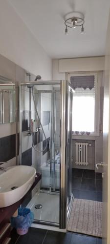 La salle de bains est pourvue d'une douche en verre et d'un lavabo. dans l'établissement Lux, à Padoue