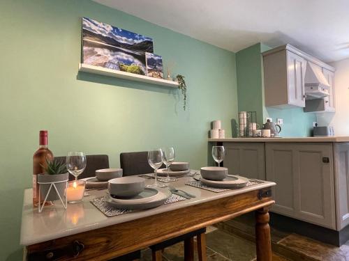 una mesa con vasos y platos en ella en una cocina en Mynydd A Môr, en Trevor