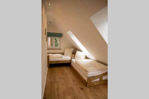 a living room with a white couch and a staircase at Zum Heuerling Ferienwohung im alten Stall mit Sauna in Versmold