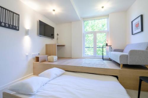 a living room with a bed and a tv at Studios with city view in Brussels