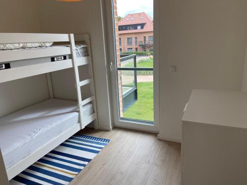 ein kleines Zimmer mit Etagenbetten und einem Fenster in der Unterkunft Wohnen am Südstrand - Ferienwohnung 1 6 in Wyk auf Föhr