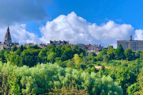 a city on a hill with trees and buildings at Le Bas Chesnay Gîte Domfront en Poiraie in Domfront