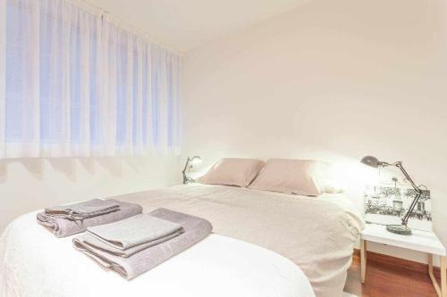 バルセロナにあるSUN RAMBLA CATALUNYA GAUDI Limpieza Desinfecciónの白いベッドルーム(タオル付きのベッド付)