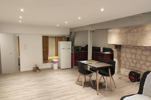 une cuisine avec une table et des chaises dans une pièce dans l'établissement Appartement en plein centre ville d'Argentan, à Argentan