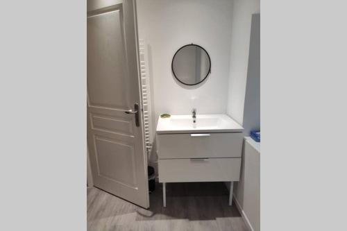 y baño con lavabo blanco y espejo. en Appartement en plein centre ville d'Argentan, en Argentan