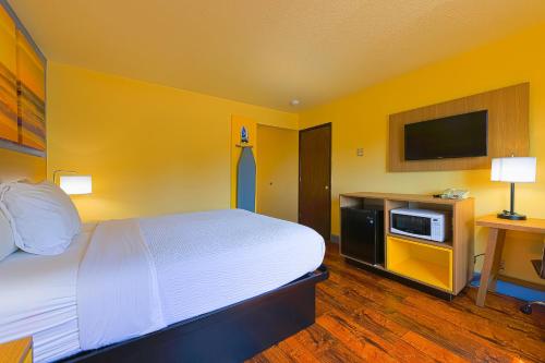 Habitación de hotel con cama y TV en Coastal Inn by OYO Lincoln City - Oregon Coast Hwy en Lincoln City