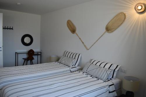 um quarto com 2 camas com almofadas listradas em Apartment Monte e Lago em Pianello Del Lario