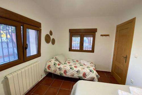 1 dormitorio con cama y ventana en Casa Cactus Preciosa casa rural con piscina y exterior privado muy amplio, en Granada