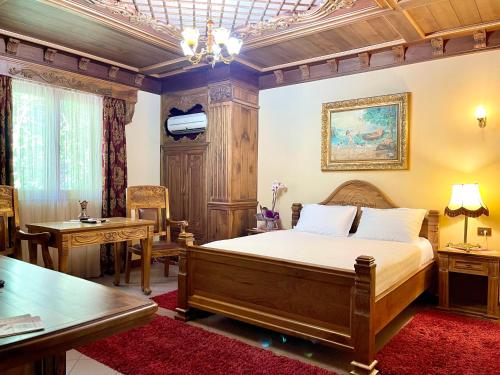 a bedroom with a bed and a desk and a table at Brilant Antik Hotel in Tirana