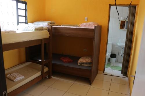 a room with two bunk beds and a bathroom at Pousada Chácara Sonho in Hortolândia