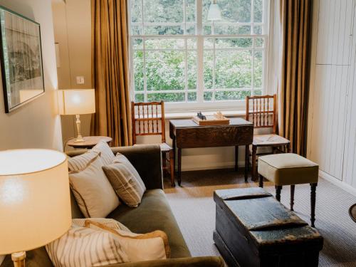 a living room with a couch and a table and a window at Beautiful Grade II Listed Gatehouse in Great Location in Sheffield