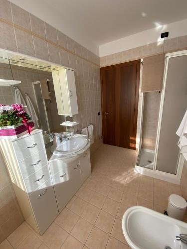 a bathroom with a sink and a toilet and a mirror at OTB Italia 2 - Alloggio accogliente tra Venezia e Treviso con 2 Terrazze e Posto auto Coperto in Preganziol
