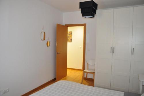 1 dormitorio con 1 cama y puerta al baño en GAIA Apartamento con piscina en Bádames, en Bádames