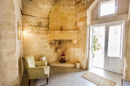 a living room with a chair and a window at Le Dodici Lune in Matera