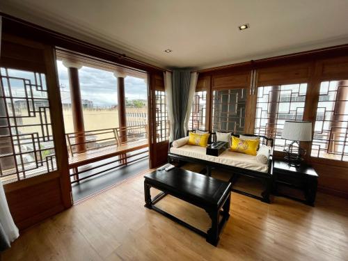 a living room with a couch and large windows at The Lantern Hatyai Hotel in Hat Yai