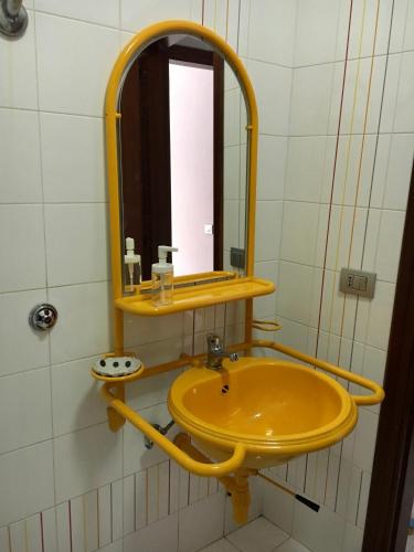 ein Badezimmer mit einem gelben Waschbecken und einem Spiegel in der Unterkunft La casetta in Rocca San Felice